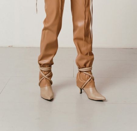 Beige boots with a pointed toe and decorative lacing