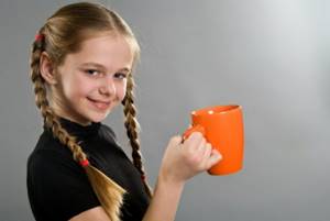 Teenage girl holding a cup of delicious cocoa in her hand