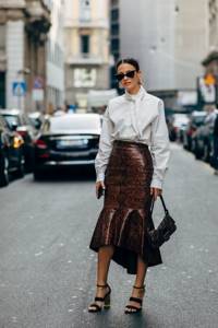 Girl in a white shirt, snakeskin leather skirt and black sandals