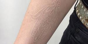 Контурная белая татуировка на руке
