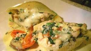 Pasta stuffed with minced meat in the oven. Recipe with cheese, mushrooms, tomatoes, basil in tomato, cream, sour cream sauce 