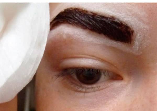 Applying cream to the area around the eyebrows