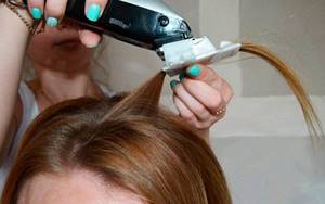 hairdresser polishing hair with a clipper attachment