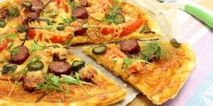 Pizza on a puff pastry crust with sausages and tomatoes