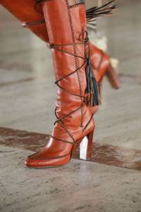 Red boots with decorative lacing and tassels